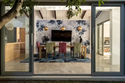 a dining room with a dining table and sliding glass doors at Benguela Cove - Lavender Dreams in Hermanus