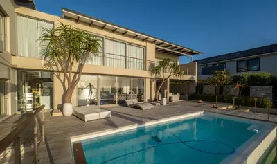 a swimming pool in front of a house at Benguela Cove - Lavender Dreams in Hermanus