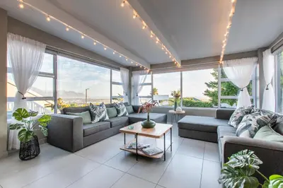 a living room with couches and a table at The Fuchsia Collection in Somerset West