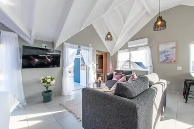 a living room with a couch and a tv at The Fuchsia Collection in Somerset West