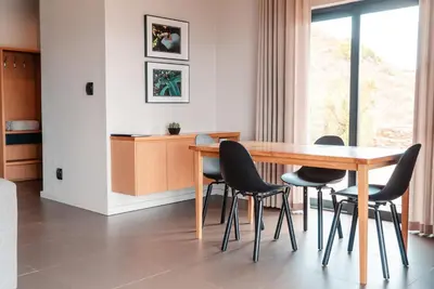 a dining room with a wooden table and chairs at Khanyisa Mountain Lodge in Robertson