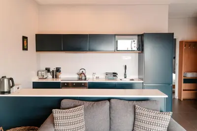a kitchen with a counter and a couch in a room at Khanyisa Mountain Lodge in Robertson