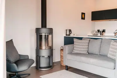 a living room with a fireplace and a couch and a chair at Khanyisa Mountain Lodge in Robertson