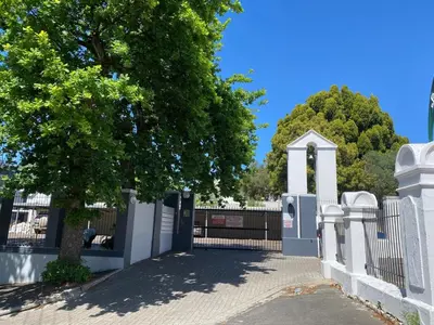 a gate with a tree in front of a fence at The Silhouette - Paarl - Self Catering Apartment in Paarl