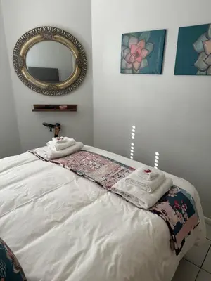 a bedroom with a bed with towels and a mirror at The Silhouette - Paarl - Self Catering Apartment in Paarl