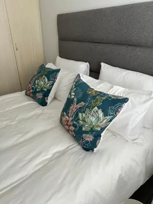 a white bed with two pillows on top of it at The Silhouette - Paarl - Self Catering Apartment in Paarl