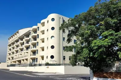 a large white building with a tree in front of it at Nautica3 in Cape Town