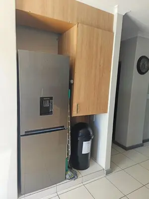 a kitchen with a refrigerator and a trash can at Nautica3 in Cape Town