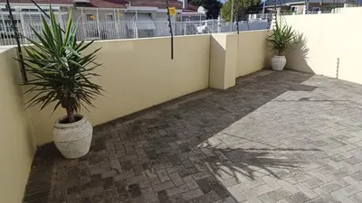 a patio with two potted plants next to a wall at Nautica3 in Cape Town