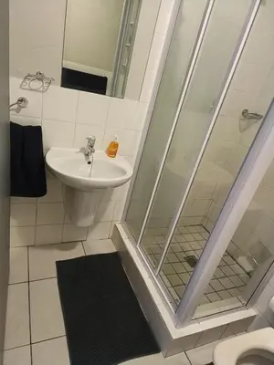 a bathroom with a shower and a toilet and a sink at Nautica3 in Cape Town