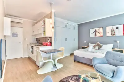 a living room with a bed and a table at WINK Aparthotel Quiver Tree in Stellenbosch