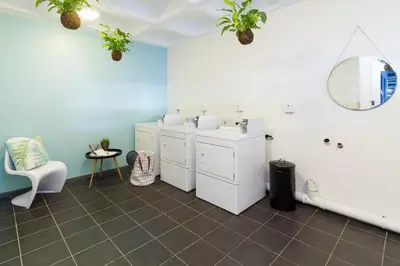 a bathroom with four washer and dryers and a mirror at WINK Aparthotel Quiver Tree in Stellenbosch