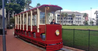 a man riding a red and white train at Cape Town Luxury Stays Knightsbridge Luxury Apartment Century City in Cape Town