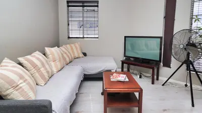 a living room with a couch and a tv at Corner View in Paarl