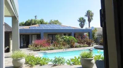 a house with a swimming pool with solar panels on it at Tucker's Self Catering Flatlet in Cape Town