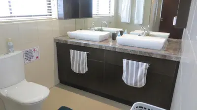 a bathroom with two sinks and a toilet at Tucker's Self Catering Flatlet in Cape Town