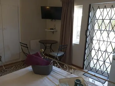 a bedroom with a bed and a table and a mirror at Rusticana in Cape Town