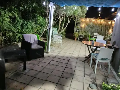 a patio at night with a table and chairs at Rusticana in Cape Town