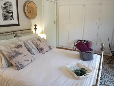 a bedroom with a white bed with a basket on it at Rusticana in Cape Town
