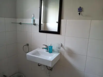 a white bathroom with a sink and a mirror at Rusticana in Cape Town