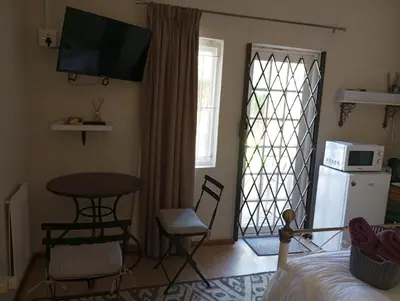 a room with a table and a table and a microwave at Rusticana in Cape Town