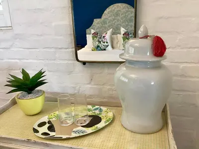 a white vase sitting on a table with a plate at Best of Both! Mountain and Sea View Home. in Hermanus