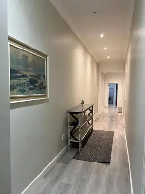 a hallway with a table and a painting on the wall at Heart of Obz in Cape Town