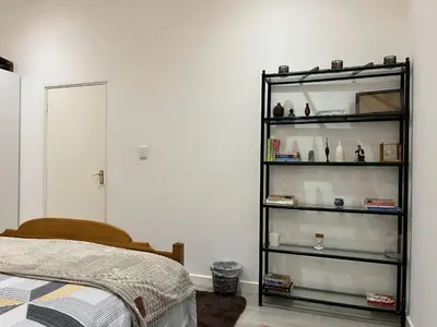 a bedroom with a black book shelf next to a bed at Heart of Obz in Cape Town
