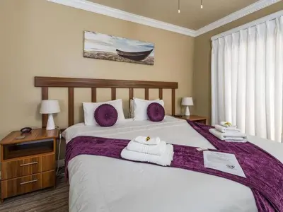 a bedroom with a large bed with towels on it at Guesthouse De Tijger Lodge in Parow