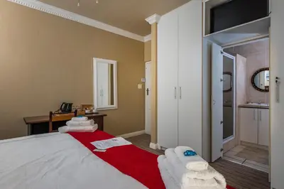 a bedroom with a bed with towels on it at Guesthouse De Tijger Lodge in Parow