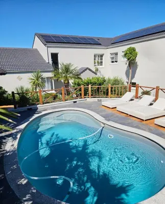 a swimming pool in the backyard of a house at Casa La Vista in Somerset West