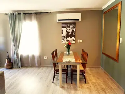 a dining room with a table and chairs and a window at Marble Maison in Franschhoek