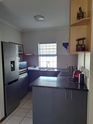 a kitchen with a stainless steel refrigerator and a sink at Casa Table View in Cape Town