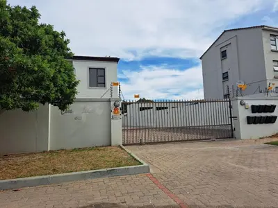 a fence in front of a white house at Casa Table View in Cape Town