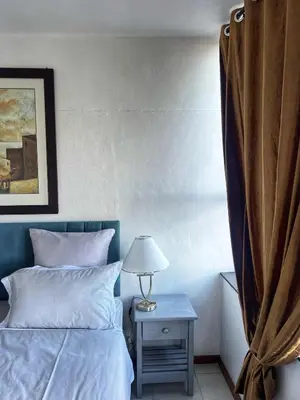a bedroom with a bed and a table with a lamp at Stay with me in Cape Town