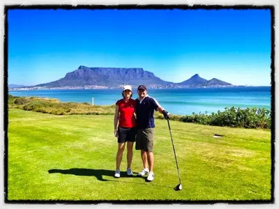 a man and a woman standing on a golf course at Lazy Days Apartments - Cape Town in Cape Town