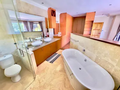 a bathroom with two sinks and a tub and a toilet at The Kite Villa - Luxury Kitesurfing Guesthouse in Cape Town