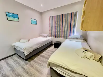 a room with two beds and a window at The Kite Villa - Luxury Kitesurfing Guesthouse in Cape Town