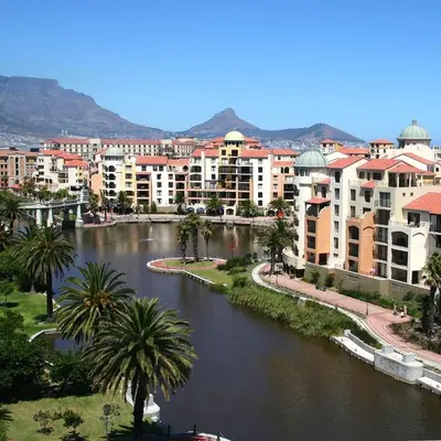 a city with a river with buildings and palm trees at The Island Club Apartment in Cape Town