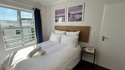 a bedroom with a large white bed with a window at 2 Bedroom Shared kitchenette Apartment with beautiful views in Stellenbosch