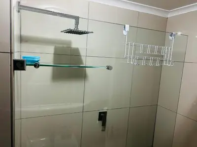 a glass shower door in a bathroom at 2 Bedroom Shared kitchenette Apartment with beautiful views in Stellenbosch