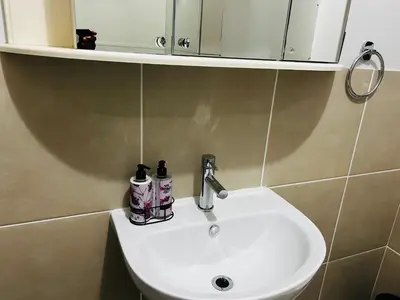 a white sink in a bathroom with a mirror at 2 Bedroom Shared kitchenette Apartment with beautiful views in Stellenbosch