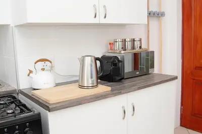 a kitchen counter with a coffee maker and a microwave at Panthera Cottage Milnerton in Cape Town