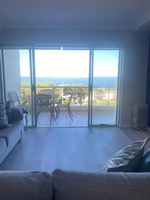a living room with a couch and a view of the ocean at 42 Whale Rock Estate in Hermanus