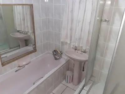 a bathroom with a sink and a tub and a toilet and a mirror at MJ's Self Catering in Wolseley