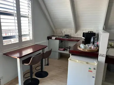 a small kitchen with a table and a microwave at Tranquility Betty's Bay in Sunny Seas