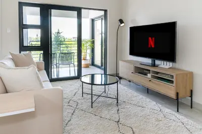 a living room with a tv and a couch at Blouberg Coastal Hideout, Luxury Apartment with a Braai and Parking in Cape Town