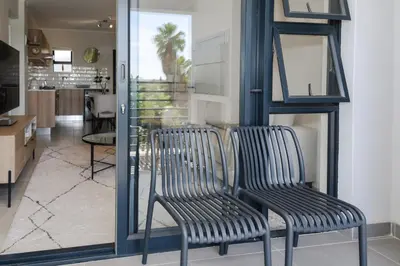 two chairs sitting in a room with a kitchen at Blouberg Coastal Hideout, Luxury Apartment with a Braai and Parking in Cape Town