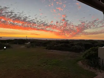 a sunset view from the porch of a house at 4-Bedroom cabana at Dolphin Beach in Cape Town