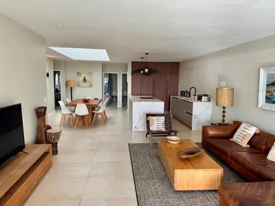 a living room with a couch and a table at 4-Bedroom cabana at Dolphin Beach in Cape Town